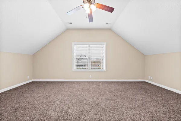an empty room with windows and chandelier fan