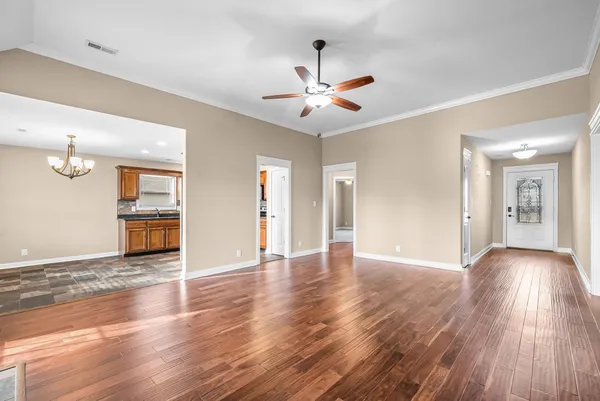 a view of an empty room with window and wooden floor