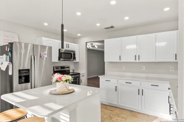 a kitchen with stainless steel appliances kitchen island granite countertop a refrigerator and microwave