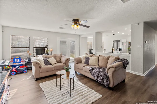 a living room with furniture kitchen view and a chandelier