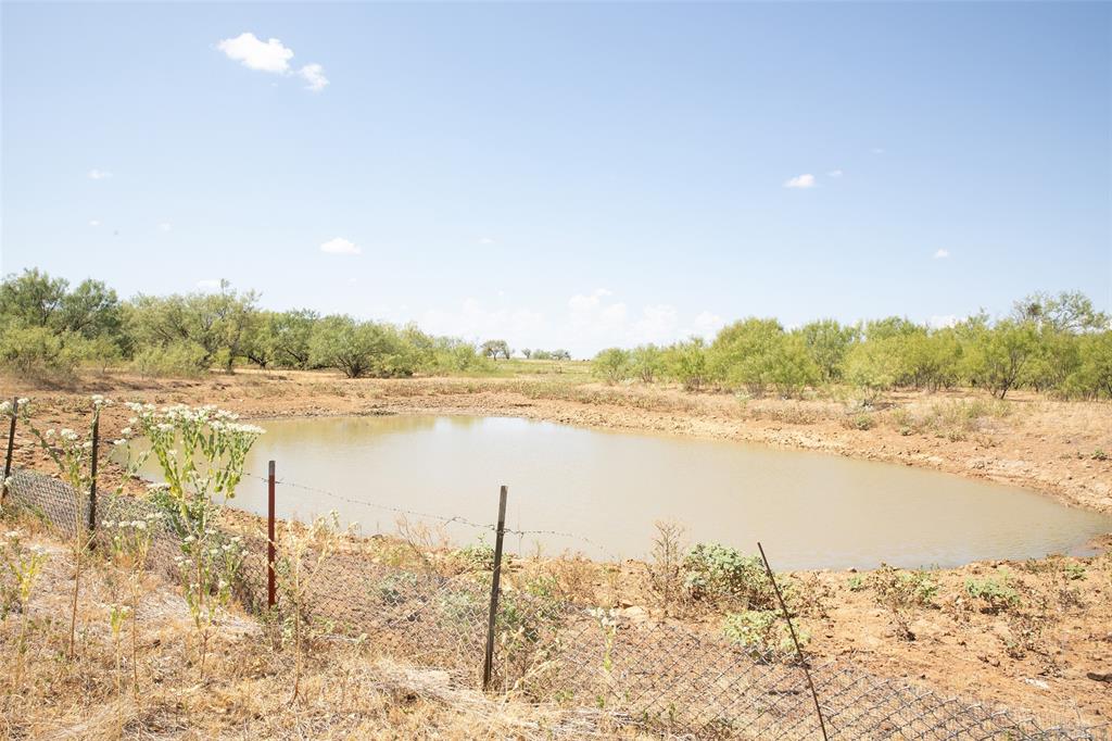 1789 Taack Road Olney, TX 76374 - Photo 10 of 18 Pond featuring surrounding natural foliage and a partial perimeter fence