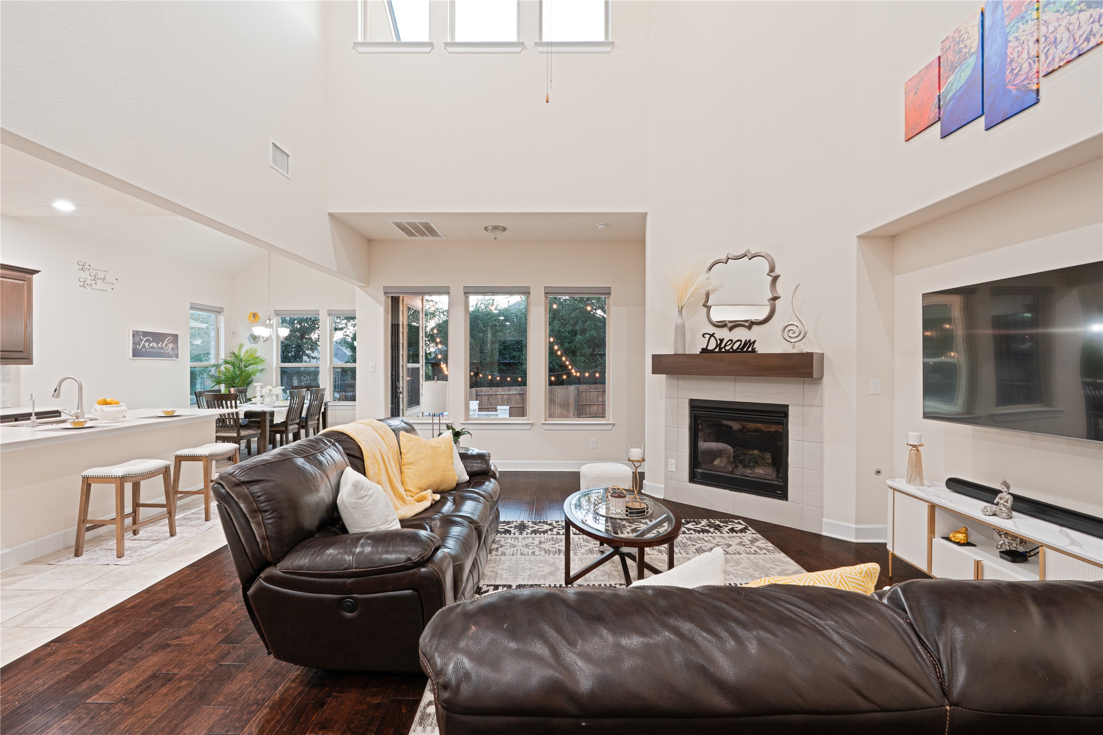 228 Lockhart Loop Georgetown, TX 78628 - Photo 8 of 37 Living room featuring a high ceiling, a tiled fireplace, and dark wood-type flooring