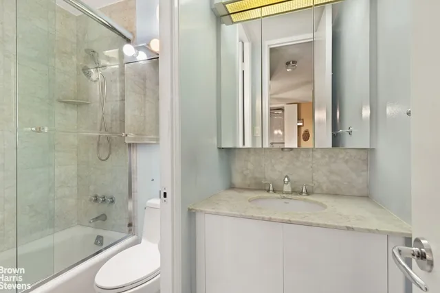 a bathroom with a granite countertop sink toilet and shower