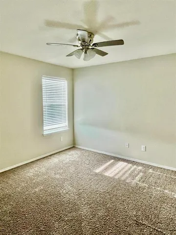 a view of a livingroom with a ceiling fan and window