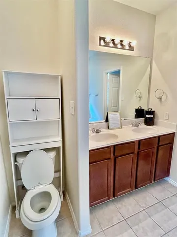 a spacious bathroom with a toilet a sink and mirror