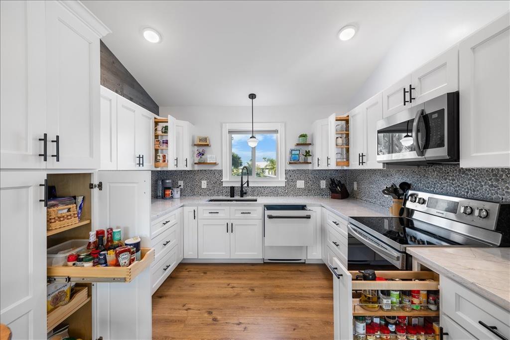 4452 Kingston Drive Hernando Beach, FL 34607 - Photo 16 of 47 a kitchen with stainless steel appliances granite countertop a stove and cabinets