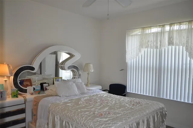 a bedroom with a bed and a large window