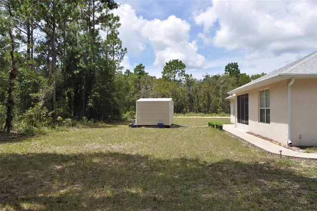 a backyard of a house with table and chairs