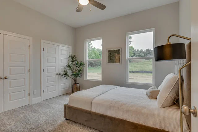 a bedroom with a bed and a large window