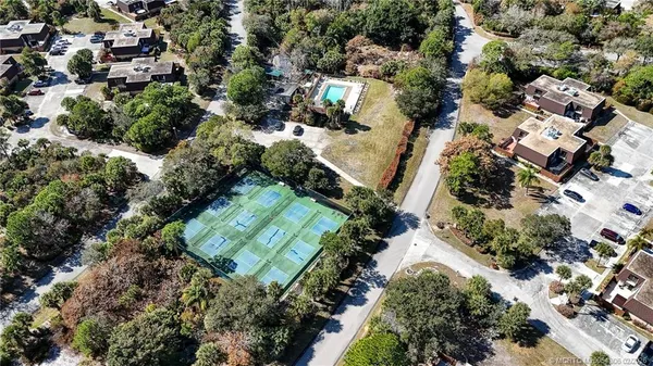 an aerial view of residential house with outdoor space and trees all around