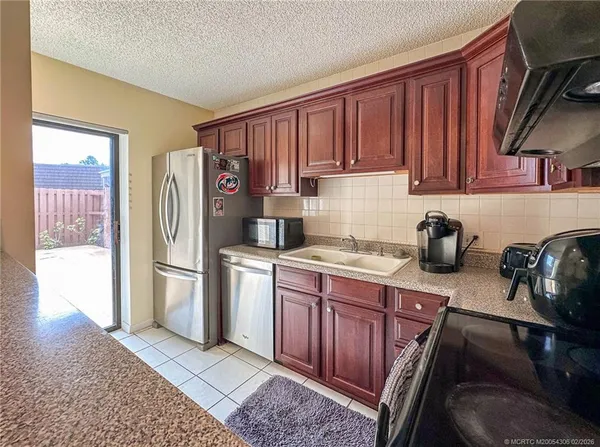a kitchen with stainless steel appliances granite countertop a refrigerator stove and sink