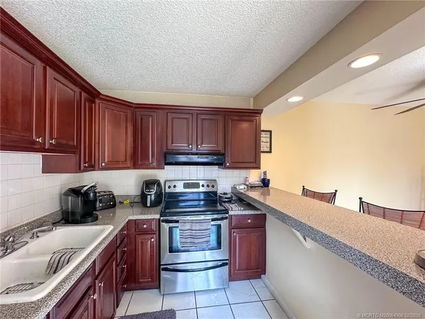 a kitchen with a sink a stove and cabinets