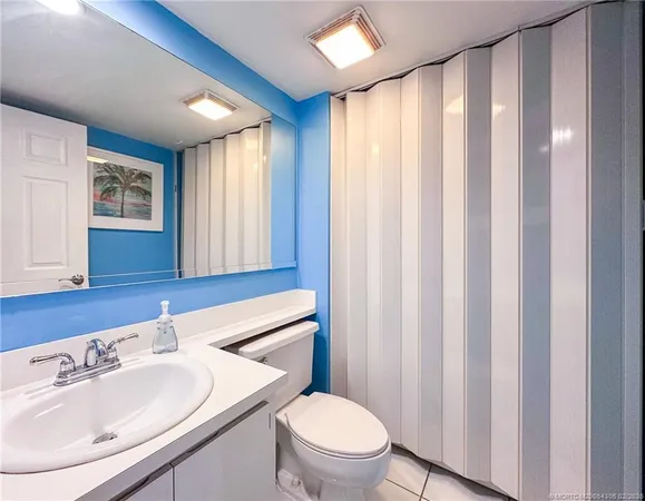 a bathroom with a sink a toilet and shower curtain