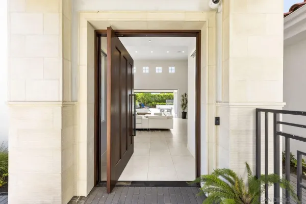 a view of a hallway with a potted plant in front of door