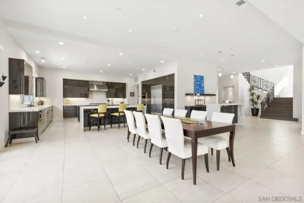 a dining room with stainless steel appliances a dining table chairs and view kitchen