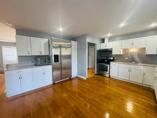 a large kitchen with cabinets and stainless steel appliances
