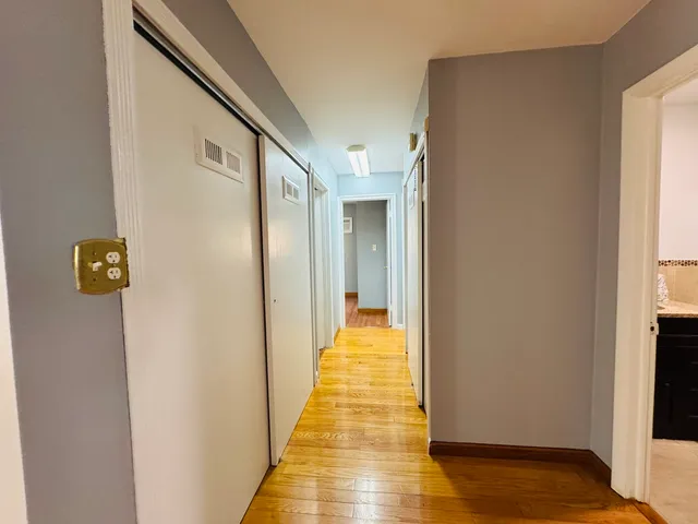 a view of a hallway with wooden floor and staircase
