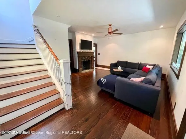 a living room with furniture and a wooden floor