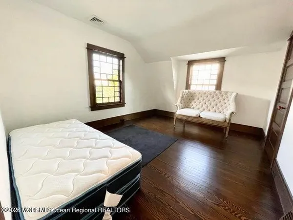 an empty room with wooden floor and window