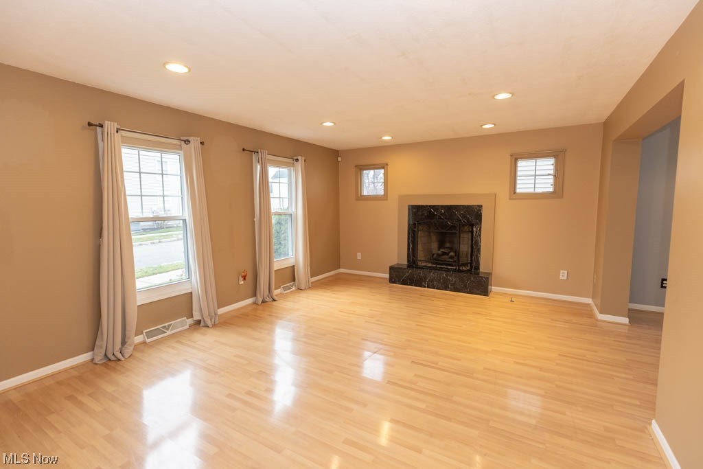 4376 Archer Road Cleveland, OH 44105 - Photo 4 of 30 Unfurnished living room featuring a high end fireplace and light hardwood / wood-style floors