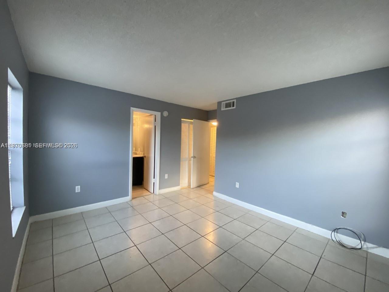 1735 West 60th Street, Unit M301 Hialeah, FL 33012 - Photo 19 of 29 a view of an empty room with window and chandelier fan
