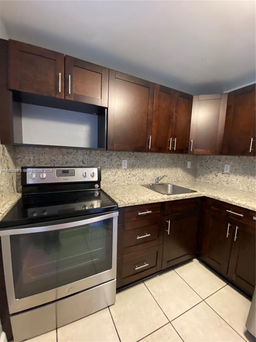 1735 West 60th Street, Unit M301 Hialeah, FL 33012 - Photo 5 of 29 a kitchen with granite countertop cabinets and steel stainless steel appliances