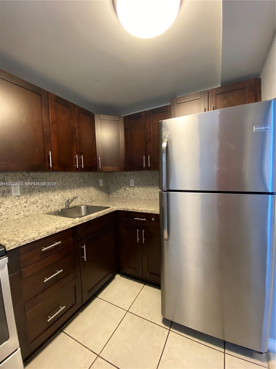 1735 West 60th Street, Unit M301 Hialeah, FL 33012 - Photo 6 of 29 a kitchen with stainless steel appliances granite countertop a refrigerator and a sink