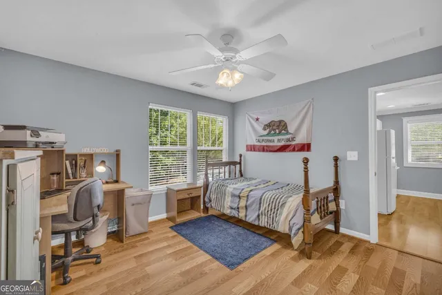 a bedroom with a bed a large window and book self