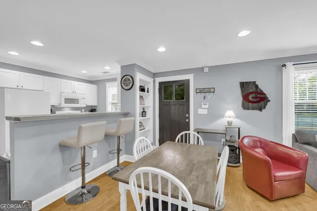 a living room with furniture a flat screen tv and kitchen view