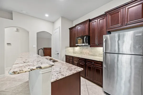 a kitchen with kitchen island granite countertop a sink stove and cabinets