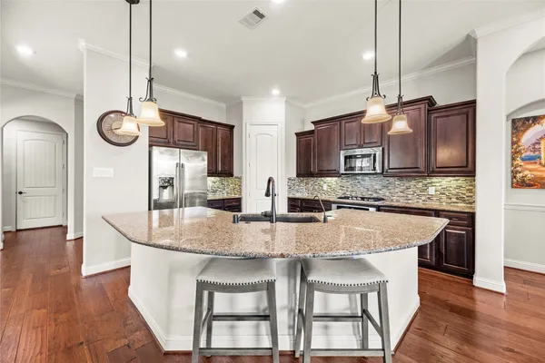 a kitchen with stainless steel appliances granite countertop a kitchen island a stove a table and chairs