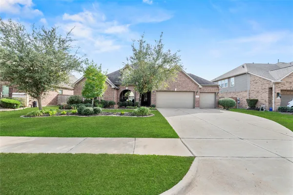 a aerial view of a house next to a yard with big trees