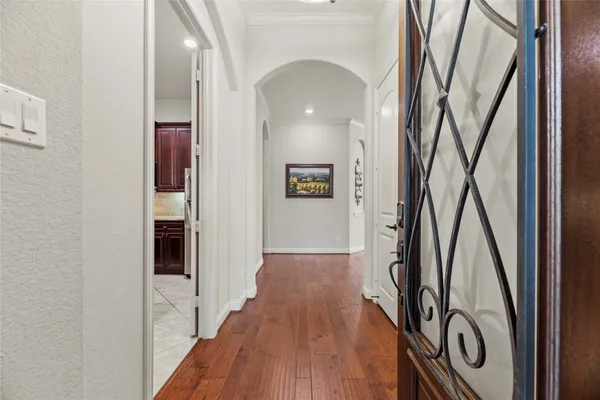 a view of a hallway with wooden floor and staircase