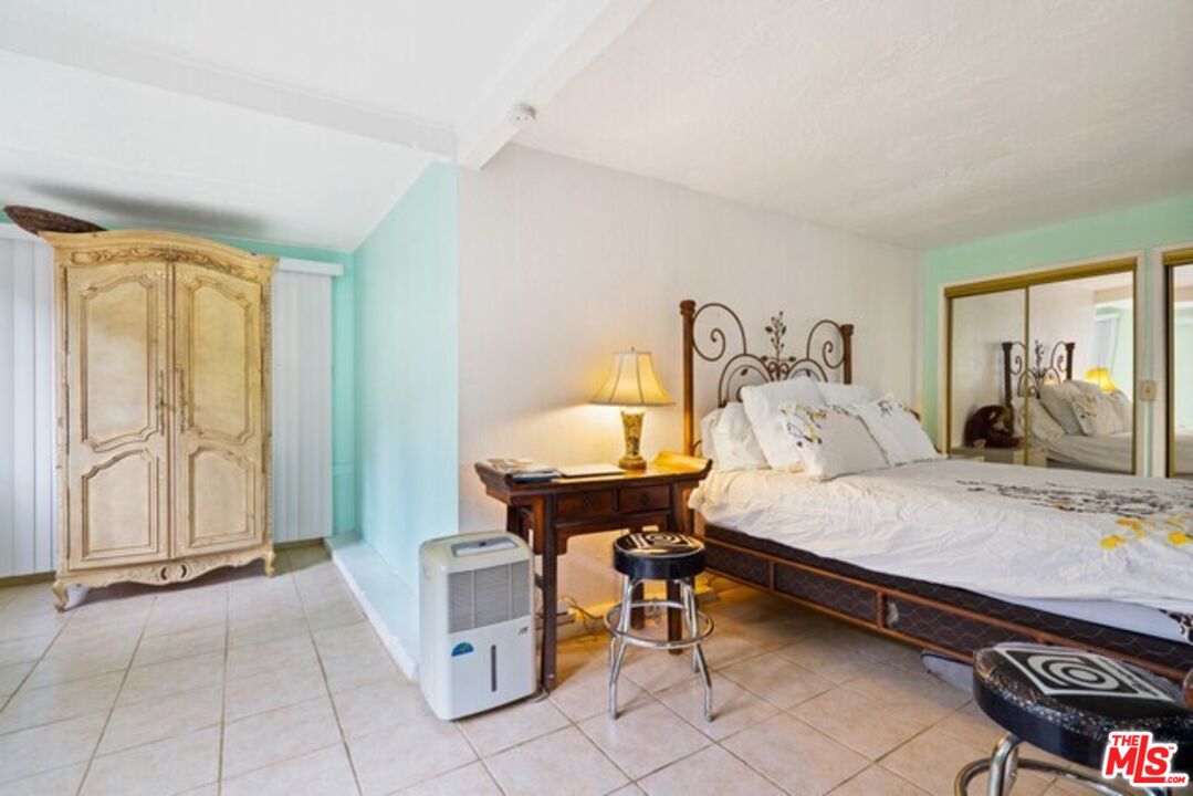 3945 Las Flores Canyon Road Malibu, CA 90265 - Photo 14 of 45 a bedroom with a bed and a table in it