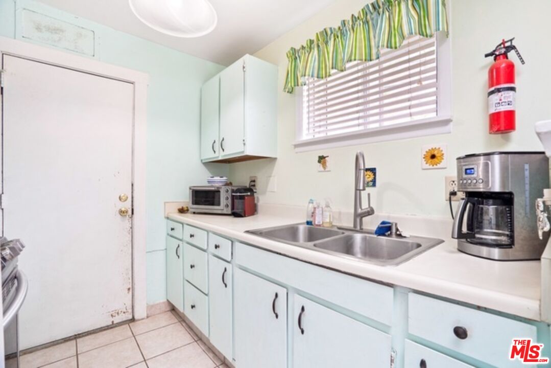 3945 Las Flores Canyon Road Malibu, CA 90265 - Photo 17 of 45 a kitchen with white cabinets and sink
