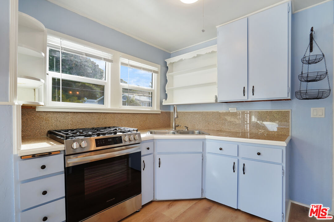 3945 Las Flores Canyon Road Malibu, CA 90265 - Photo 27 of 45 a kitchen with granite countertop white cabinets and white appliances