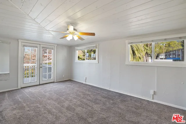 an empty room with chandelier fan