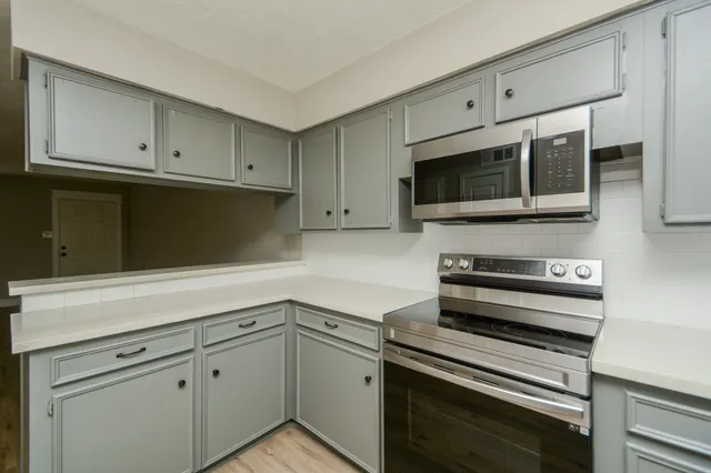 a kitchen with cabinets stove and microwave
