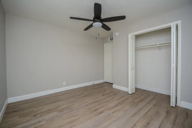 a view of room with hardwood floor and ceiling fan