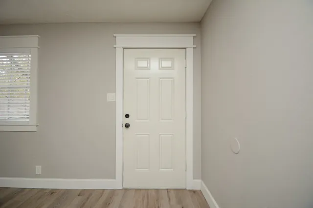 an empty room with wooden floor and closet