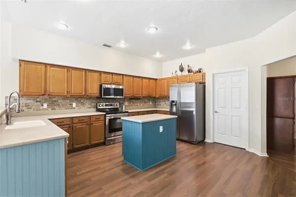 a kitchen with stainless steel appliances granite countertop a sink stove and refrigerator