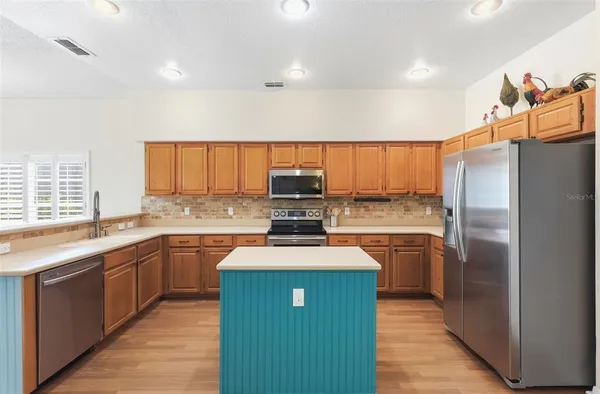 a kitchen with stainless steel appliances granite countertop a stove top oven and sink
