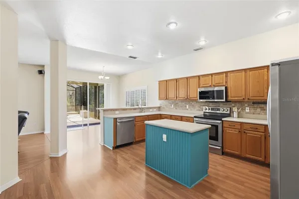 a large kitchen with stainless steel appliances granite countertop a stove a sink dishwasher and a refrigerator