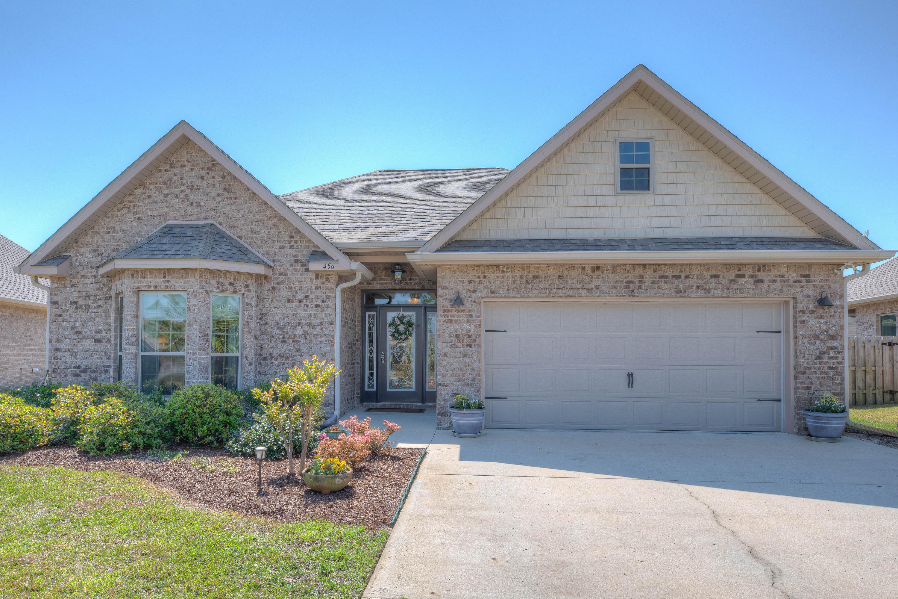 456 Pin Oak Loop Santa Rosa Beach, FL 32459 - Photo 1 of 32 a front view of a house with a yard and potted plants