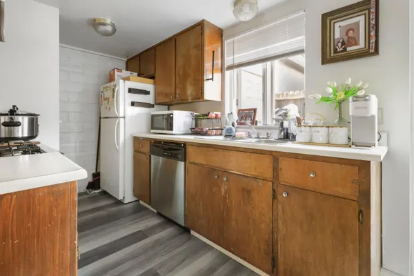 a kitchen with stainless steel appliances granite countertop a sink a stove a refrigerator with grey cabinets