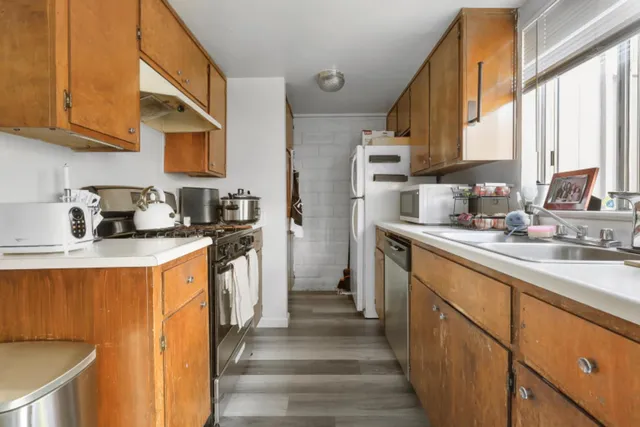a kitchen with sink a refrigerator and cabinets