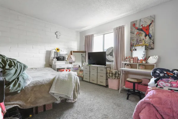 a bedroom with furniture and a flat screen tv