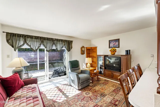 a living room with furniture a rug and a flat screen tv