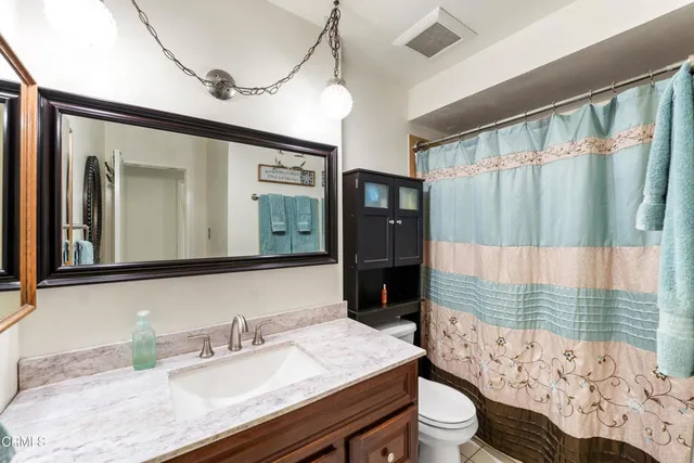 a bathroom with a granite countertop sink mirror vanity and toilet