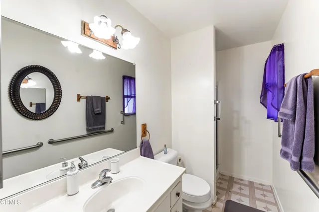 a bathroom with a toilet a sink and a mirror